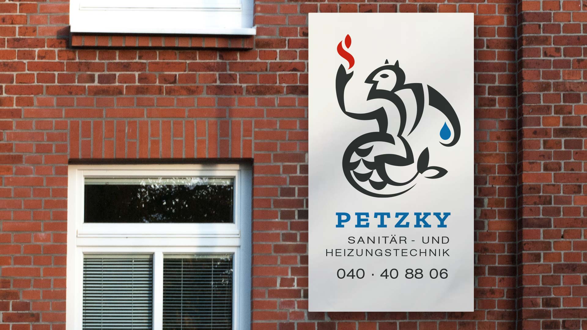 an einer Backsteinfassade hängendes Schild der Firma Petzky Sanitär- und Heizungstechnik